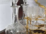 bottles and glasses are sitting on a shelf with a mirror in the background
