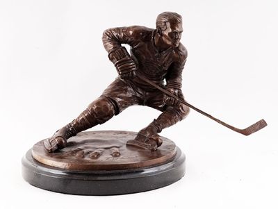 statue d'un joueur de hockey tenant une crosse, posée sur un socle