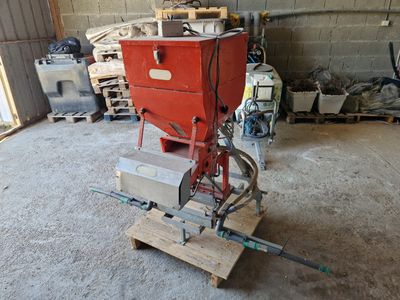 une machine rouge posée sur une palette dans un garage