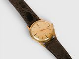a close up of a watch on a white surface with a brown strap