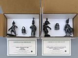 two boxes with figurines of soldiers in them sitting on top of a table