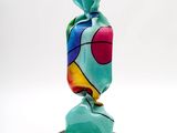 a close up of a colorful sculpture on a black stand
