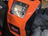 un appareil orange et noir posé sur une table, à côté d'un ordinateur portable
