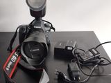 un appareil photo Canon posé sur une table à côté d'un chargeur