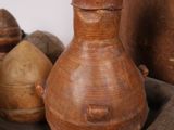 a brown vase sitting on top of a wooden tray next to other vases