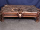 an antique carved coffee table with a bird on top of it