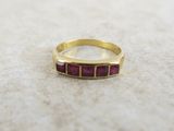 a picture of a gold ring with pink stones