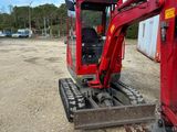 a red excavator that is sitting in the dirt