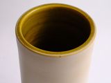 a white cup with a yellow rim sitting on a table