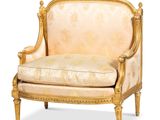 a gold colored chair with a beige upholstered seat