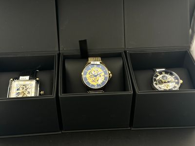 trois montres dans un coffret noir posé sur une table
