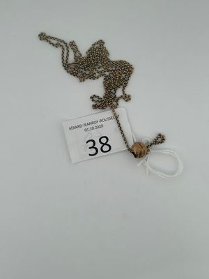 a close up of a necklace on a white surface with a price tag