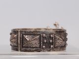 un bracelet ancien en argent exposé dans une vitrine