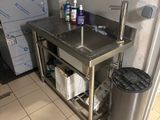 a kitchen with a sink and a trash can in it