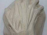 plaster sculpture of a woman ' s head on a white surface