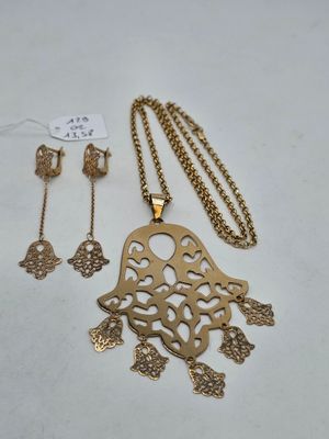 a gold necklace and earring set with a bird pendant
