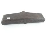 an old wooden object on a white surface with a tag on it