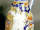 a white pitcher with a blue and yellow design on it