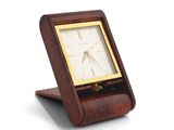 a wooden clock that is on a stand on a white surface