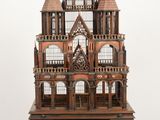 a wooden doll house on a table on a wooden floor