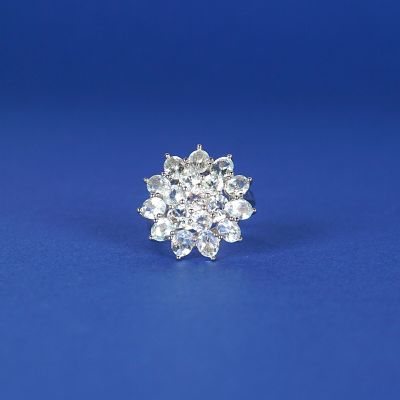 un gros plan d'une bague en forme de flocon de neige posée sur une surface bleue