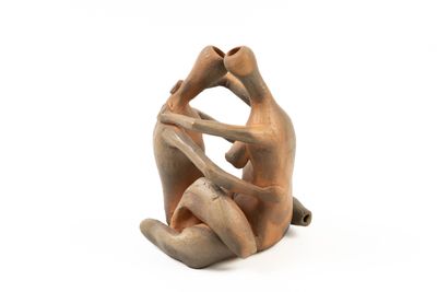 figurine of a man and woman sitting on a white surface