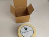 une petite boîte avec un couvercle et un petit récipient posés sur une table