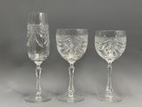 three clear wine glasses sitting next to each other on a table
