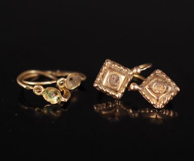 a pair of gold earrings and a gold ring