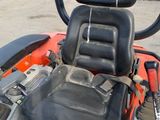 an orange tractor with a black seat and a black seat on it