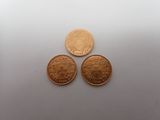three different types of coins are shown on a white surface