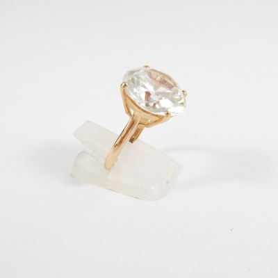 a close up of a gold ring with a white topaz stone