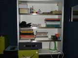 a desk with a chair and bookshelf in the corner