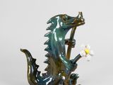 figurine de dragon tenant une fleur dans la gueule, sur fond blanc