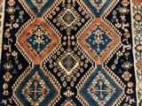 a blue and orange rug with a diamond design on it