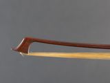 a close up of a bow with a wooden handle on a gray background