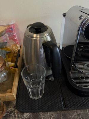 une cafetière et un verre posés sur une table