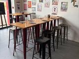 des tables et des tabourets dans une pièce où sont accrochées des affiches au mur