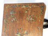 a small wooden table with a floral design on it