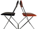 two folding chairs with black and orange leather seats on a white background