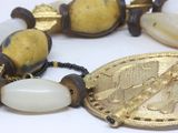 a close up of a necklace with a coin on it