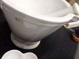 a white toilet bowl with a brush in it on a black table