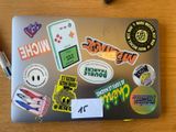 a laptop covered with stickers and magnets on a table