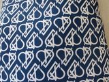 a close up of a blue and white pillow on a couch
