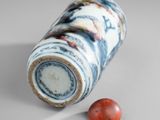 an image of a vase with a red bead on the ground