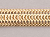 a close up of a piece of gold colored metal on a gray surface