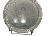 une assiette en argent sur laquelle est représentée une femme