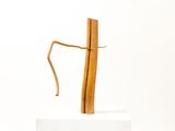 a sculpture of a wooden stick on a white pedestal