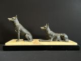 bronze sculpture of two dogs sitting on a wooden base