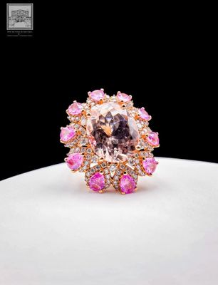a close up of a pink and white diamond ring on a white plate